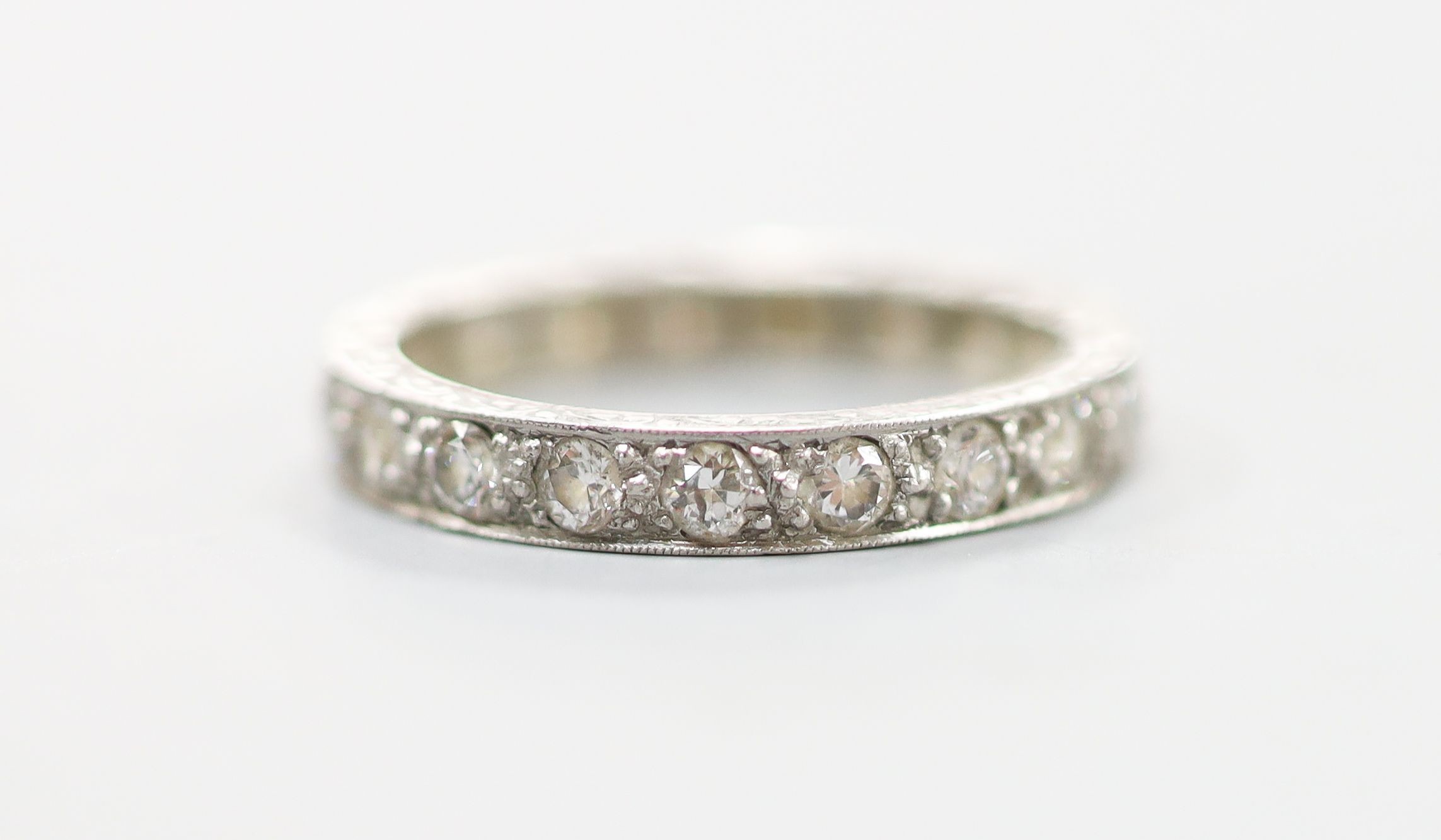 An engraved white metal and diamond set full eternity ring, size P, gross weight 4.1 grams.